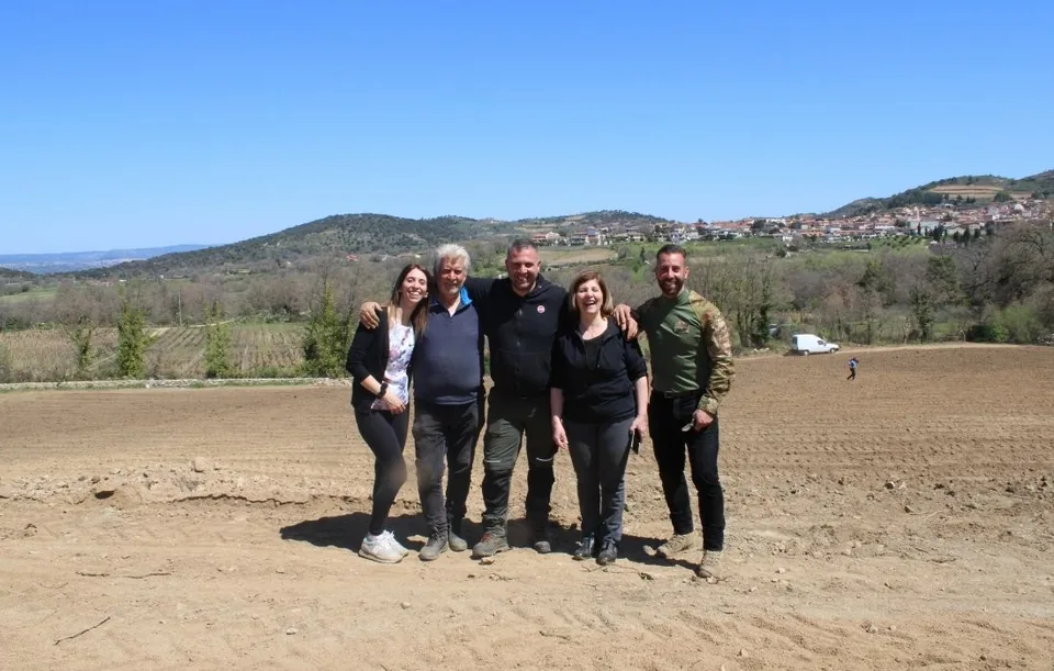 The Mussennore family standing on the newly prepared Conzimu plot, with Mamoiada on the hillside behind